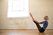 Female dancer sitting on floor with legs raised