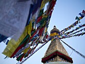 Flags hang from a Buddhist temple (Stupa) as people gather in Kathmandu, Nepal.