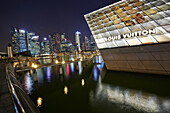The Loius Vuitton Island Maison, a luxury shop designed by architect Peter Marino located in Marina Bay. In the background the skyscrapes of the Central Business district. Singapore.