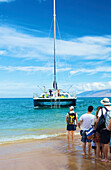 'Tourists lining up on the shore waiting for a boat; Hawaii, United States of America'