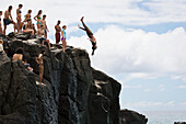 'People enjoy a 30 foot high jump at ''da big rock'' in Waimea Bay; North Shore, Oahu, Hawaii, United States of America'