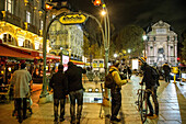Lively nighttime ambiance at the exit from a metro station, fountain and place saint-michel square, latin quarter, 5th arrondissement, paris at nght, france