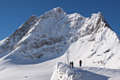 Tourists looking at the summit of the jungfraujoch from the jungfraujoch pass, bernese alps, canton of bern, switzerland