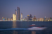 Yacht sailing in front of the skyscrapers of abu dhabi, united arab emirates, middle east