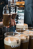 Serving dark draught ale at the old brewery, guinness storehouse, dublin, ireland