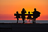 Family on a bench by the seaside, cayeux-sur-mer, somme, picardy, france