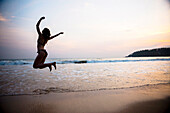 Tourist jumping on Mirissa Beach at sunset, South Coast of Sri Lanka, Southern Province, Sri Lanka, Asia