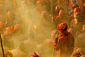 Throwing orange and yellow colors at the Nandgaon temple during Holi festival celebration, Nandgaon, Mathura, India