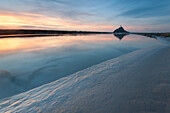 Couesnon river with high tide at sunset with Mont Saint Michel in the background, France