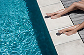 Caucasian women sunbathing by swimming pool, Cape Town, Western Cape, South Africa