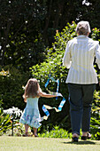Senior Caucasian woman and granddaughter playing outdoors, Cape Town, Western Cape, South Africa