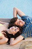 Couple relaxing by swimming pool, Palma de Mallorca, Balearic Islands, Spain