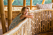 Caucasian girl leaning over railing, Ubud, Bali, Indonesia