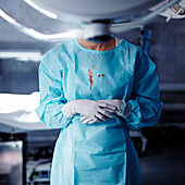 Caucasian surgeon with blood on gown in operating room, Nizniy Tagil, Sverdlovsk, Russia