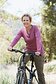 Senior Caucasian woman riding bicycle on rural path, Los Angeles, United States, United States