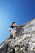 Hispanic climber scaling steep rock face, Tiburon, CA, USA