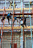 Workers in a hardhat navigating scaffolding in a major construction project  in Ho Chi Minh City, Vietnam, South East Asia, Asia