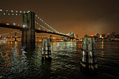 Brooklyn Bridge at night. Stakes in the Hudson