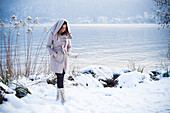 young woman walking in the snow at annecy's lake