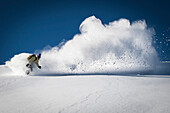 Female snowboarder making a powder turn, Areches Beaufort, France