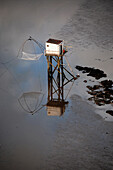 Aerial view of a white dip at low tide. Its reflection in a puddle