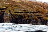 Iceland. Southern region. Glacier Svinafellsjokull. Tourists walking on the glacier.