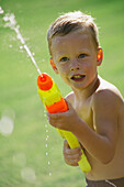 Little Boy Playing With A Watergun