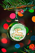 An Ornament With A Reindeer Hanging From A Christmas Tree