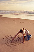 'A Girl Drawing In The Sand At Los Lances Beach Along Costa De La Luz; Tarifa, Cadiz, Andalusia, Spain'