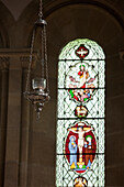 'A Light Fixture And Stained Glass Window In Howick Church; Northumberland, England'
