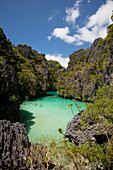 'Tourists Kayak Inside The Scenic Small Lagoon On Miniloc Island, Near El Nido; Bacuit Archipelago, Palawan, Philippines'