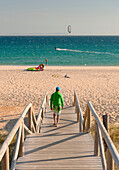 'A Man Walks Down A Wooden Boardwalk To Valdevaqueros Beach; Tarifa, Cadiz, Andalusia, Spain'
