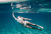 'A Woman Swimming Underwater Wearing A Two Piece Bathing Suit; Tarifa, Cadiz, Andalusia, Spain'