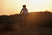 'A Cyclist Rides On A Path At Sunset; Tarifa, Cadiz, Andalusia, Spain'