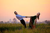 'Portrait Of A Mixed Race Couple Her Wearing A Sari In A Field At Sunset; Ludhiana, Punjab, India'