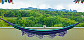 'A hanging hammock with mountains and lush vegetation in the background;Wailua kauai hawaii united states of america'