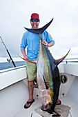 'Man holding a fresh caught yellowfin tuna; panama'