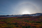 'A halo around the sun is seen over the cloud enshrouded richardson mountains;Yukon canada'