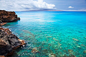 'A view of la perouse bay with clear water and coral with kooholawae in the distance;Maui hawaii united states of america'