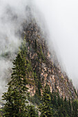 Clouds covering the steep cliff on the side of a mountain