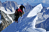 Mountaineer passing cornices on the ridge of Tour Ronde, Mont Maudit, Mont Blanc Group, France