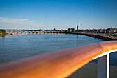 Deck railing of cruise ship MS Deutschland (Reederei Peter Deilmann) and Pont de Pierre bridge across La Garonne river, Bordeaux, Gironde, Aquitane, France