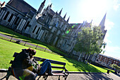 Couple sitting on a bench infront of St. Patrick's Cathedral, Dublin, Ireland