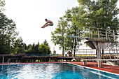 Mann springt vom Sprungturm in einem Schwimmbad, Leipzig, Sachsen, Deutschland