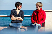 Two women in conversation at Mediterranean Sea, Noto, Syracuse, Sicily, Italy