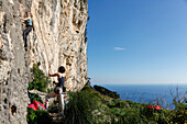Woman rock climbing, Taormina, Messina, Sicily, Italy