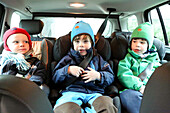 Three children sitting in a car