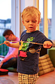 Boy (3 years) holding a folding ruler, Leipzig, Saxony, Germany