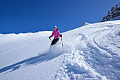 Female back-country skier downhill skiing from Eiskoegele, Obergurgl, Oetztal Alps, Tyrol, Austria