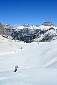 Female back-country skier downhill skiing from Corno d Angolo, Cristallo Group, Dolomites, Veneto, Italy